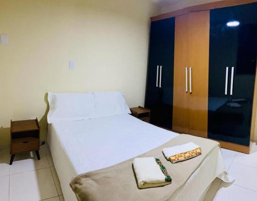 1 dormitorio con 1 cama con 2 toallas y armario en Ape Atalaia, en Aracaju