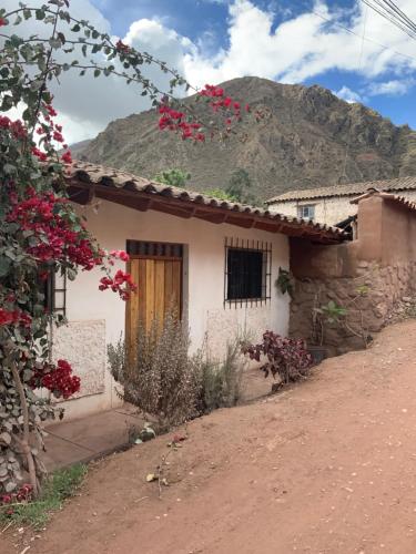 uma pequena casa com uma montanha ao fundo em Casas de campo para riders em Urubamba