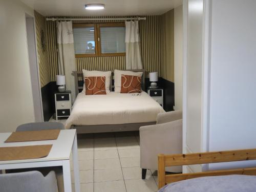 a bedroom with a bed and a table and chairs at Les Collinades de Chalons in Châlons-en-Champagne