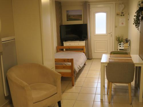 een slaapkamer met een bed, een stoel en een bureau bij Les Collinades de Chalons in Châlons-en-Champagne