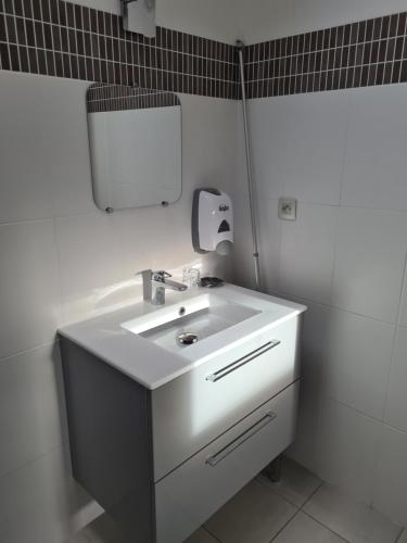 y baño con lavabo blanco y espejo. en Les Chambres du Meunier en Juigné-sur-Loire