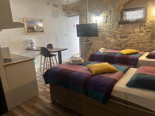 a hotel room with two beds and a table and a desk at Elena Rooms Split in Split