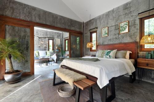 a bedroom with a large bed and a living room at Boutique Jungle Villa - Baan ChaOm in Ko Lanta