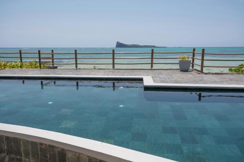 una piscina con el océano en el fondo en Luxury beachfront duplex, Coin de Mire view / 3Bed, en Cap Malheureux