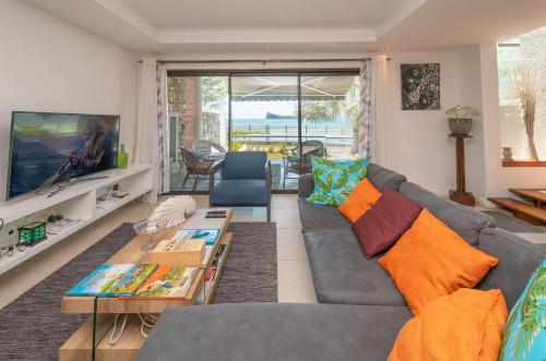 Una televisión o centro de entretenimiento en Luxury beachfront duplex, Coin de Mire view / 3Bed