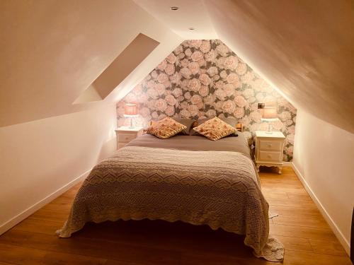 a bedroom with a large bed in a attic at La Villa des Roses - Suite & Spa in Lys-lès-Lannoy