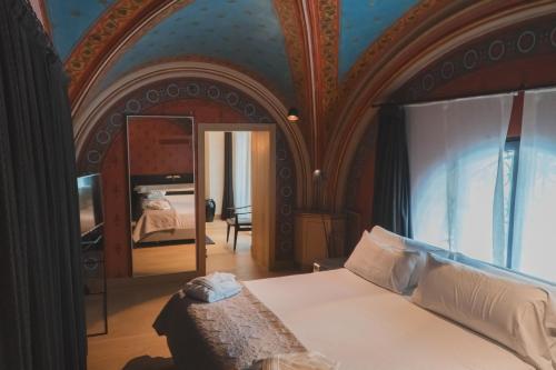 a bedroom with a large bed and a mirror at Zenit Convento San Martin in San Sebastián
