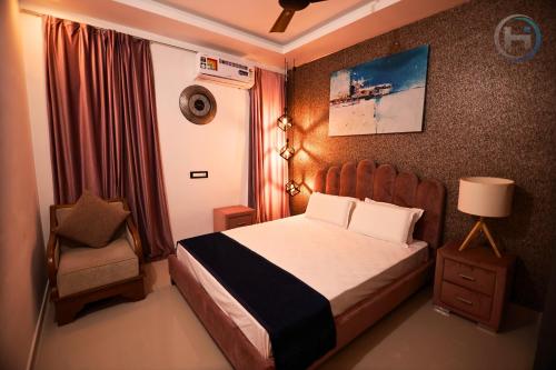 a small bedroom with a bed and a chair at Holiday Island in Kollam, Nearby Varkala in Kollam
