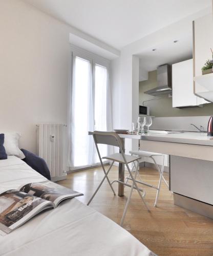 a white kitchen with a desk and a table at MARCONA 1 - City Centre Apt with Terrace in Milan
