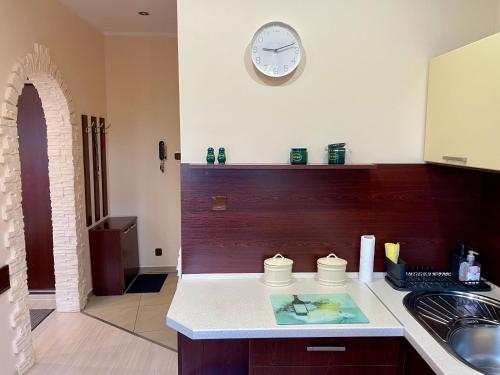 a kitchen with a counter and a clock on the wall at City & Sea - Apartamenty i Mieszkania in Gdynia