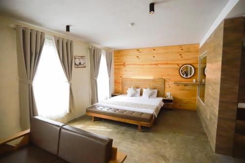 1 dormitorio con 1 cama y 1 sofá en Rustic Hotel Quy Nhon Powered by ASTON en Quy Nhon