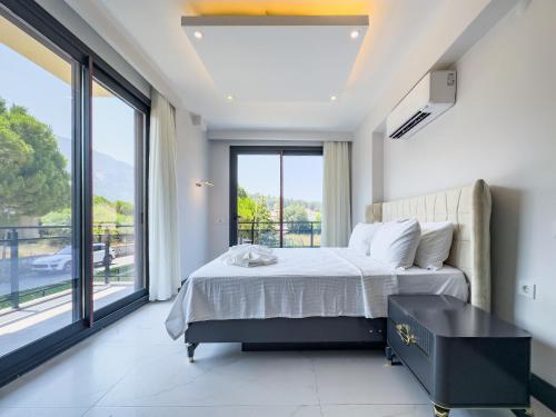 a bedroom with a bed and a large window at CAPELLA VİLLAS in Fethiye