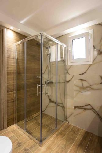 a shower with a glass door in a bathroom at Feel Meteora 1BD luxury apt in Kalabaka