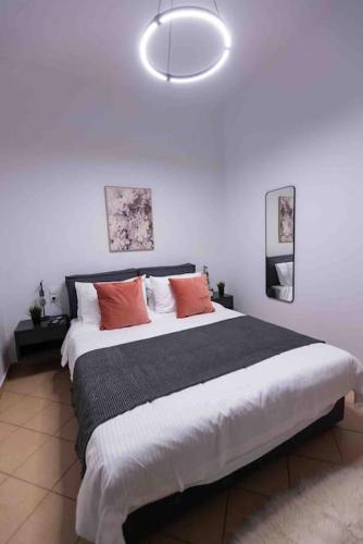 a bedroom with a large bed with orange pillows at Feel Meteora 1BD luxury apt in Kalabaka