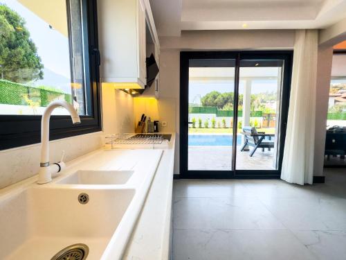 a kitchen with a sink and a view of a patio at CAPELLA VİLLAS in Fethiye