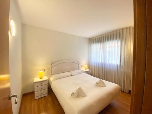 a bedroom with a white bed with two lamps on it at Sol-Ski in El Tarter