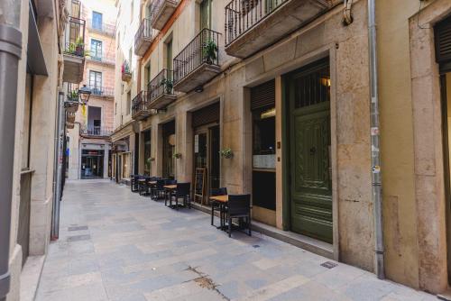 an empty street with tables and chairs in an alley at Bravissimo Mercaders 3, Old Town Oasis in Girona