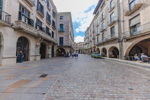 a cobblestone street in a city with buildings at Bravissimo Mercaders 3, Old Town Oasis in Girona