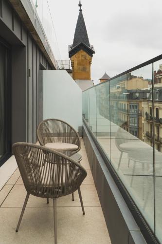 a balcony with two chairs and a table on a building at Zenit Convento San Martin in San Sebastián