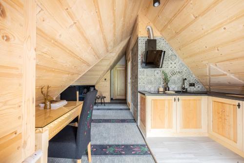 a kitchen with a wooden ceiling and a table at Highlander Heart Residence in Zakopane