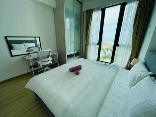 Jazz Suite Ocean View Netflix SmartTV في Tanjong Tokong: غرفة نوم بسرير عليها غرض وردي