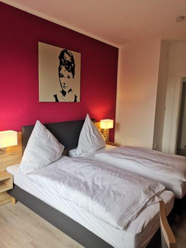 1 dormitorio con 1 cama grande y pared roja en Becky´s Kolpinghaus, en Recklinghausen