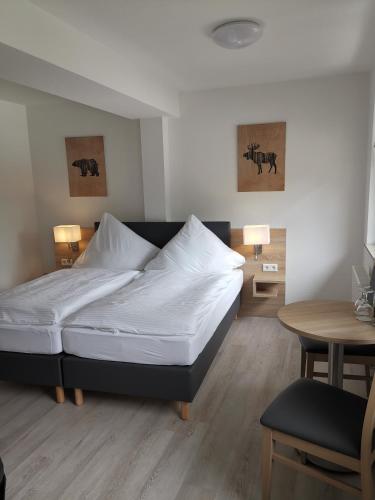 1 dormitorio con 1 cama con sábanas blancas y mesa en Becky´s Kolpinghaus, en Recklinghausen