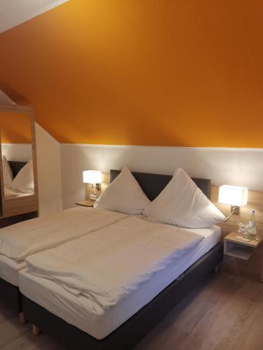 ein Schlafzimmer mit einem großen Bett mit zwei Lampen in der Unterkunft Becky´s Kolpinghaus in Recklinghausen