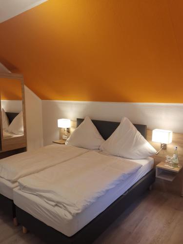 a bedroom with a large bed with two lamps at Becky´s Kolpinghaus in Recklinghausen
