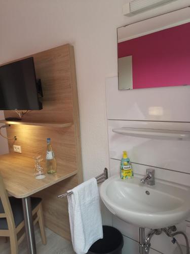 a bathroom with a sink and a toilet and a table at Becky´s Kolpinghaus in Recklinghausen