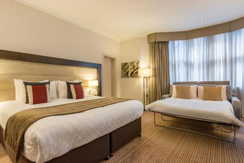 a hotel room with two beds and a window at Thistle London Holborn in London