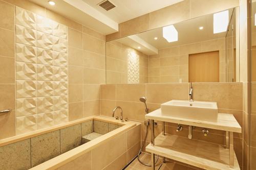 a bathroom with a sink and a bath tub at Grand Prince Hotel Takanawa in Tokyo