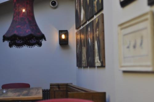 una habitación con una mesa y una luz en la pared en The Three Pigeons Inn, en Banbury