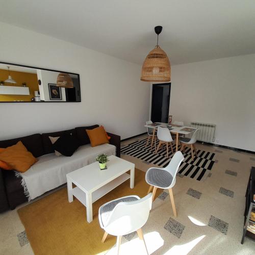 un salon avec un canapé, une table et des chaises dans l'établissement Hyper Centre Sanary 3 chambres parking balcon clim wifi, à Sanary-sur-Mer