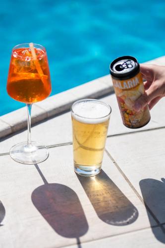 two drinks on a table next to a can of beer at International Hotel & Suite in San Benedetto del Tronto