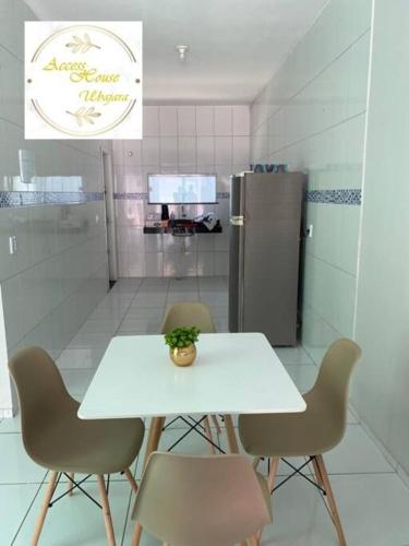 - une table et des chaises dans la cuisine équipée d'un réfrigérateur dans l'établissement Access House Ubajara:Sua casa na Serra Grande CE, à Ubajara