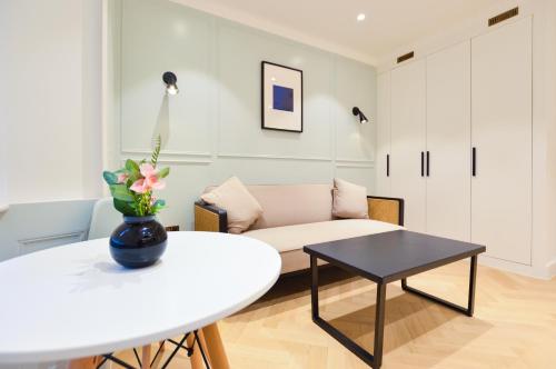 un soggiorno con tavolo bianco e divano di Star Street Serviced Apartments by Concept Apartments a Londra