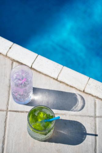a drink in a glass next to a swimming pool at International Hotel & Suite in San Benedetto del Tronto