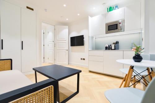 a living room with a table and a kitchen at Star Street Serviced Apartments by Concept Apartments in London