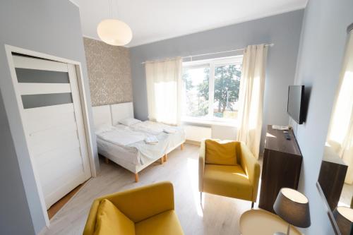 um pequeno quarto com uma cama e uma cadeira em Słoneczna em Sieraków
