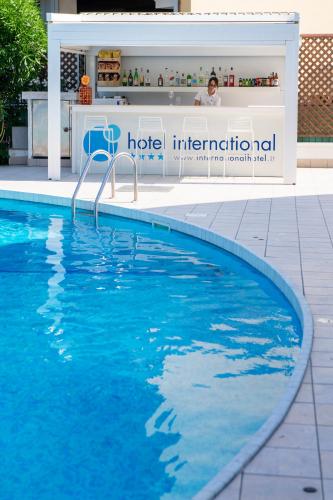 a swimming pool with a hotel international sign next to it at International Hotel & Suite in San Benedetto del Tronto