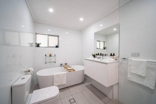a white bathroom with a tub sink and a toilet at Pethick House in McLaren Vale