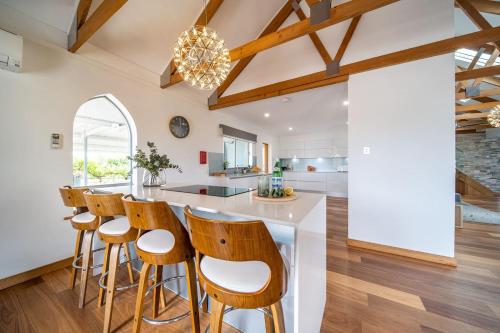 a kitchen with wooden floors and a bar with stools at Pethick House in McLaren Vale