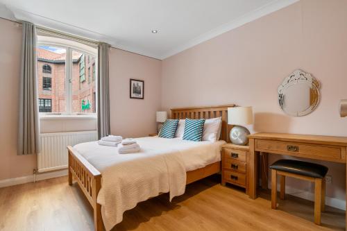 a bedroom with a bed and a desk and a window at 5 St Georges House Lovely 1-Bed Apartment Right in the Heart of York Pass the Keys in York