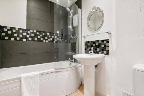 a white bathroom with a sink and a tub and a toilet at Lovely Apartment in Central York - Pass the Keys in York