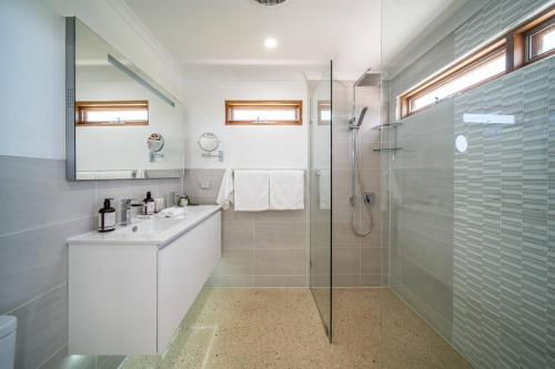 a white bathroom with a shower and a sink at Pethick House in McLaren Vale