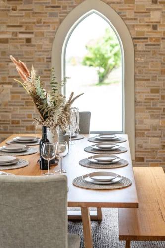 a dining room table with plates and wine glasses at Pethick House in McLaren Vale