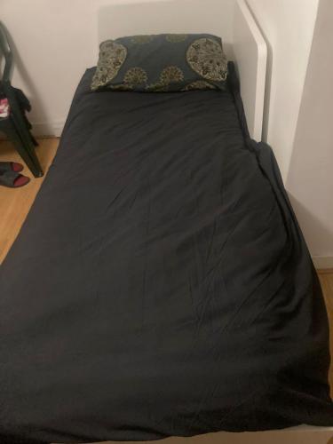 1 cama con edredón negro y almohada en Inviting 1-Bed Studio in London en Londres