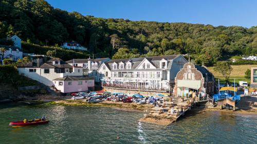 an aerial view of a town with a boat in the water at South Sands Hotel in Salcombe