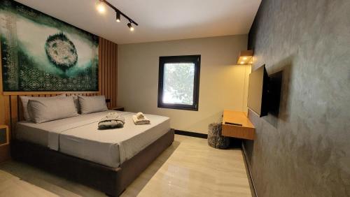 a bedroom with a bed and a flat screen tv at Yalikavak Residence Apartment in Bodrum City